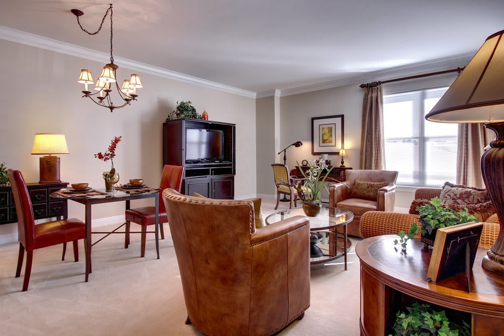 A cozy living room with a connected dining area featuring elegant furniture and warm lighting.
