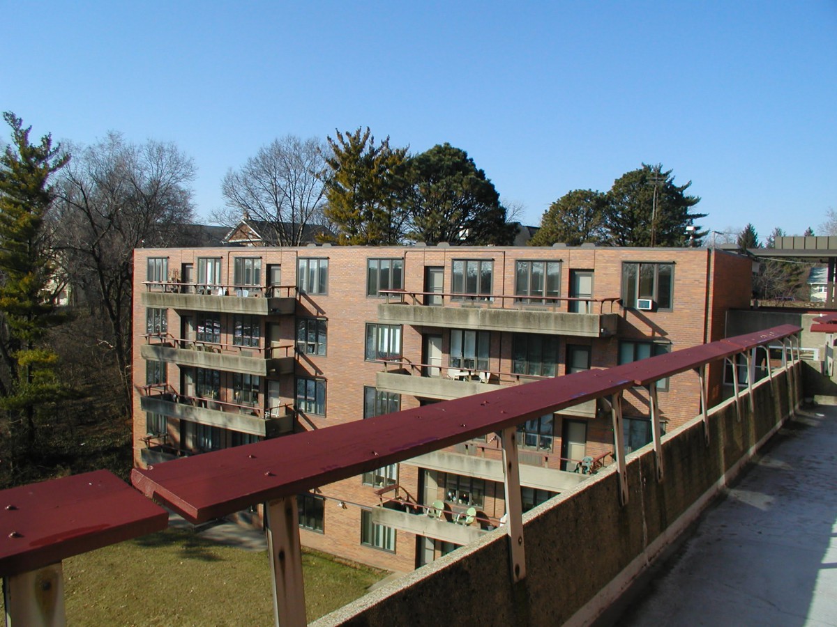 A view of a multi-story apartment building with balconies on a clear day.