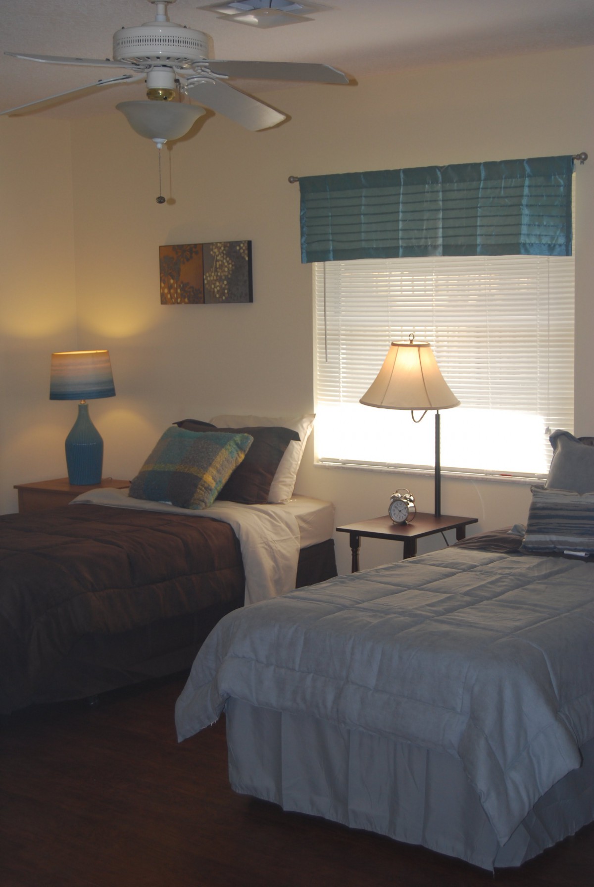 A cozy bedroom with two twin beds and warm lighting from lamps.