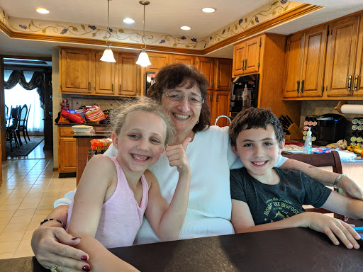 A joyful moment captured with a grandmother and her grandchildren in the kitchen.