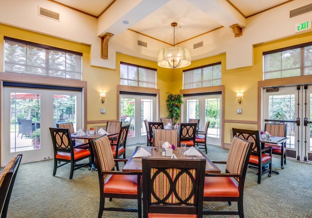 A well-lit dining area with elegantly arranged tables and chairs, showcasing sophisticated interior design.