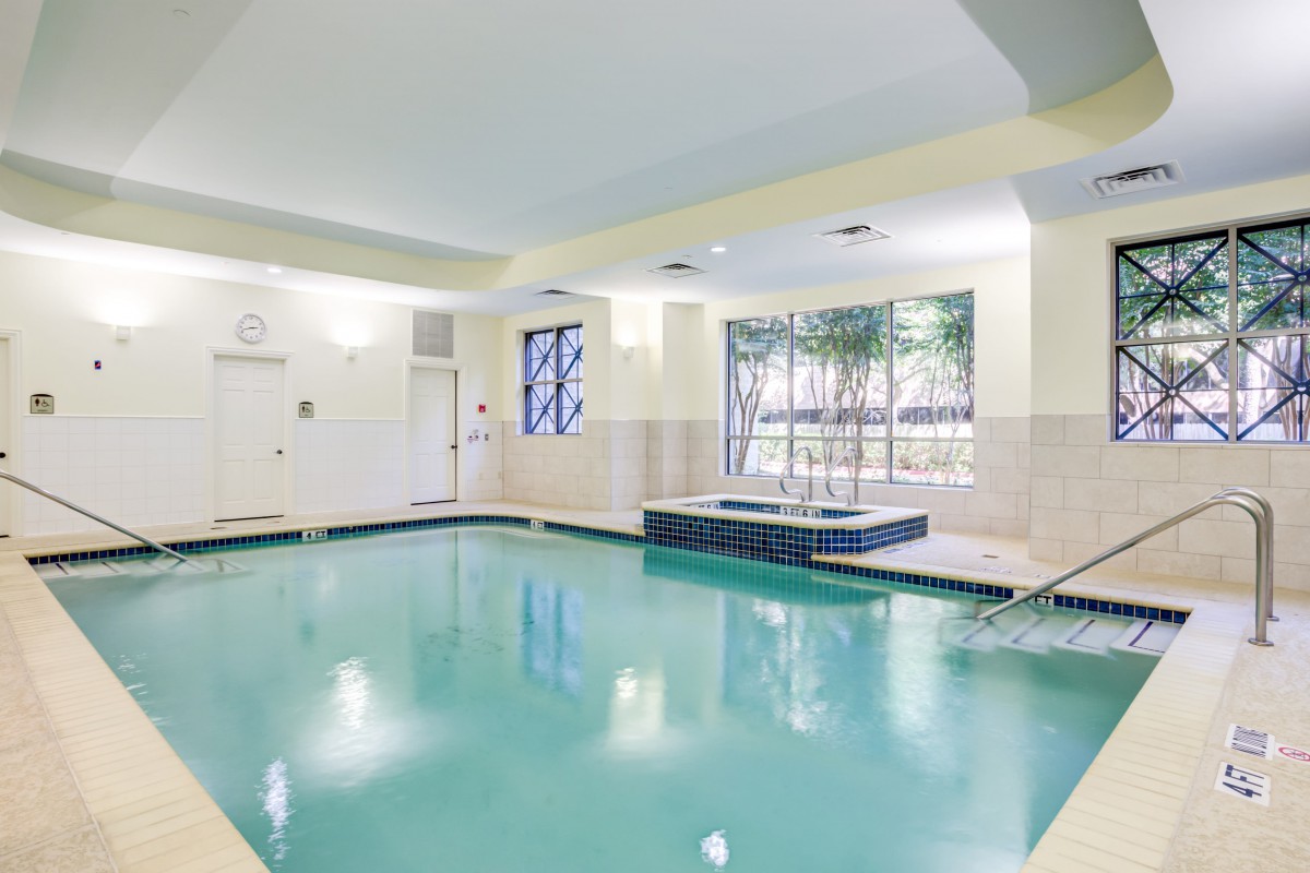 An inviting indoor swimming pool area with natural light streaming in through the windows.