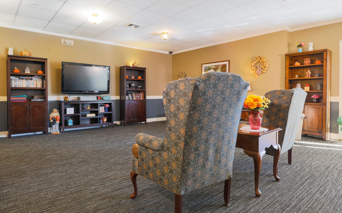 A cozy living room with an armchair, television, and decorative elements.