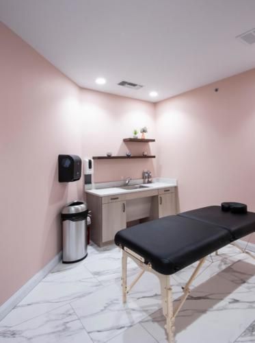 A tranquil massage room with a treatment table and modern amenities.