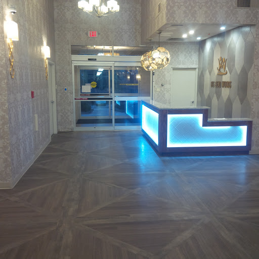 A modern lobby with an illuminated reception desk and stylish decor.