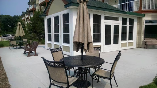 A cozy outdoor seating area featuring a table, four chairs, and an umbrella.