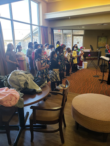 A lively group of individuals gathered indoors, engaging in a choir performance.