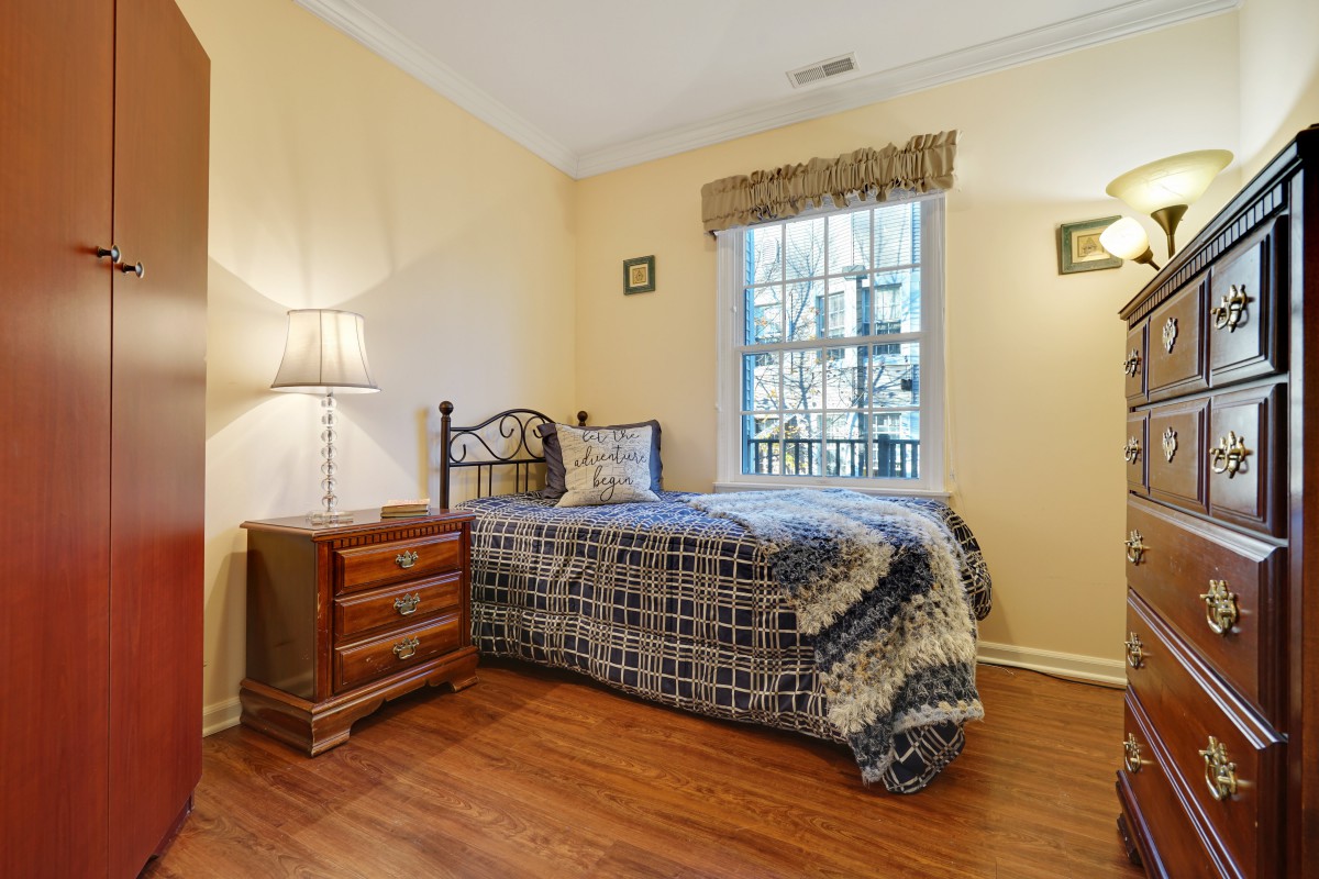 A cozy bedroom with a single bed and wooden flooring.