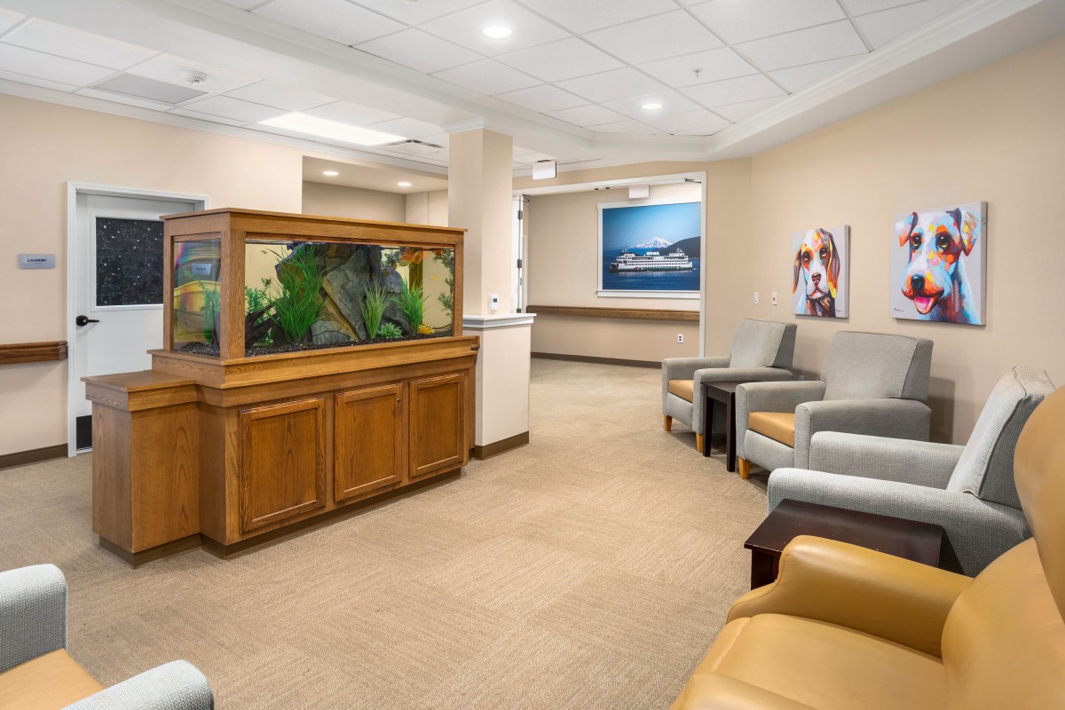 A spacious waiting room with comfortable seating and a large aquarium.