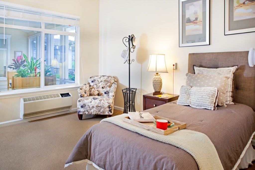 A cozy bedroom with a comfortable armchair and warm lighting.