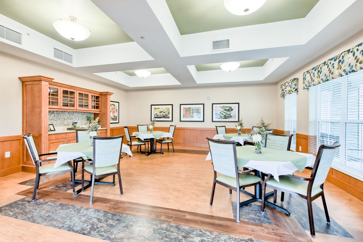 A bright and spacious dining room with neatly arranged tables and chairs.