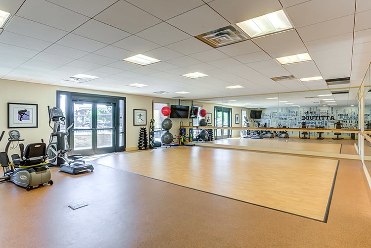 An empty fitness studio equipped with mirrors and exercise equipment.