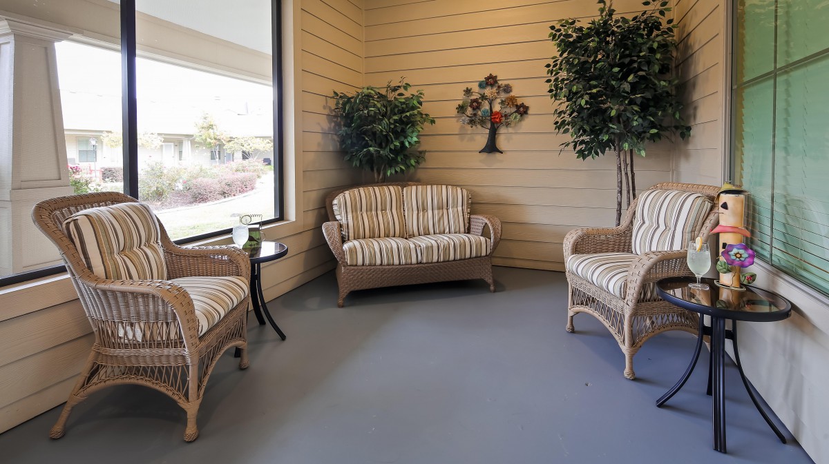 Cozy indoor seating area with wicker furniture and decorative plants.