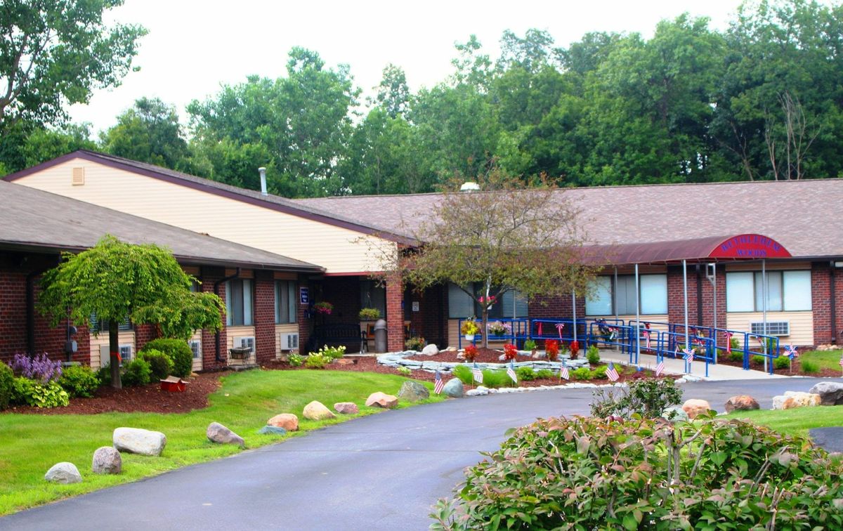 A well-maintained building with a landscaped garden and driveway.