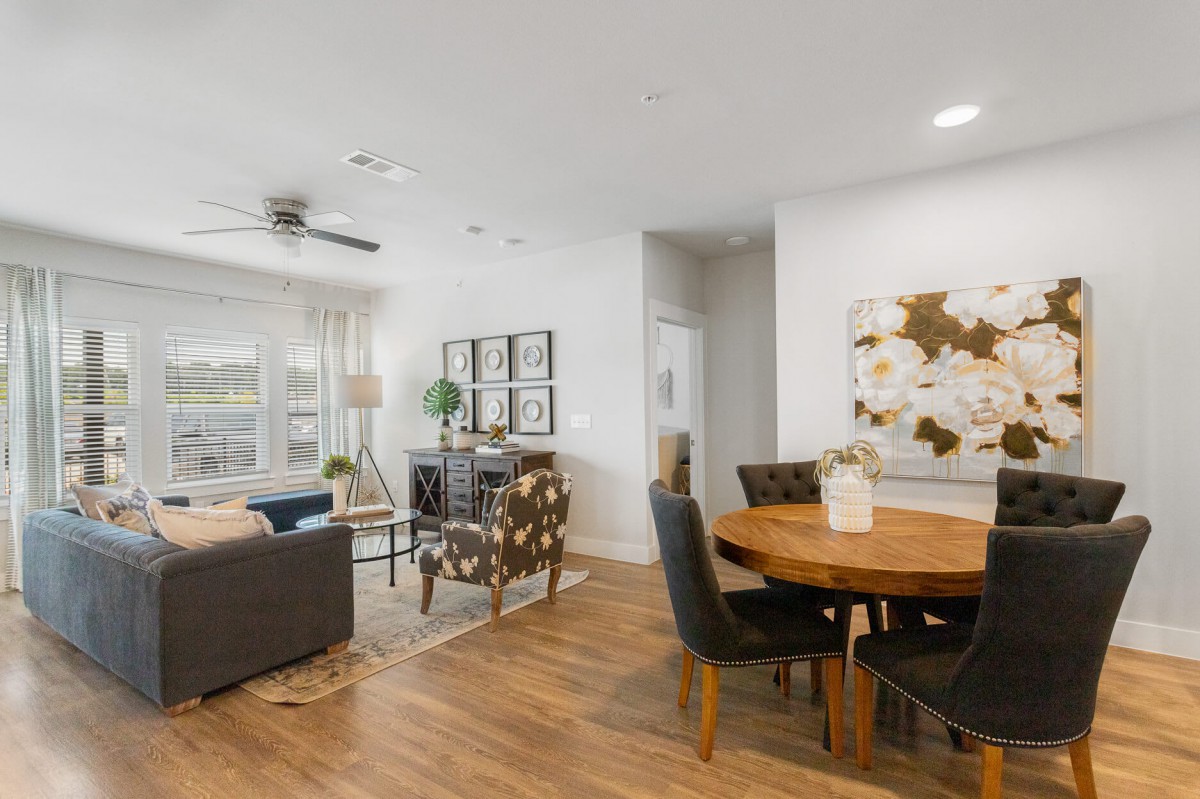 A modern open-plan living room and dining area with stylish furnishings and wood flooring.