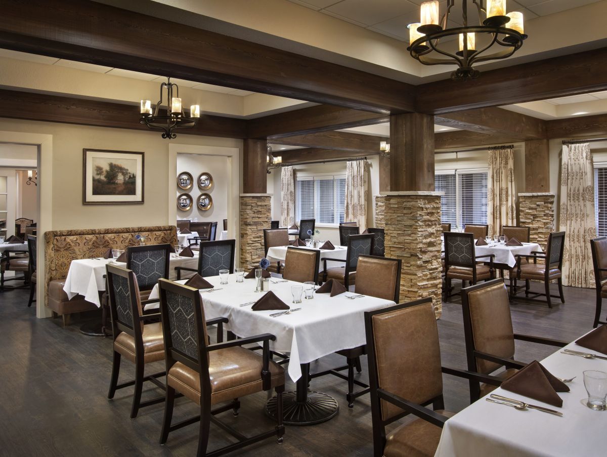 An elegantly decorated restaurant dining room with neatly arranged tables and soft lighting.