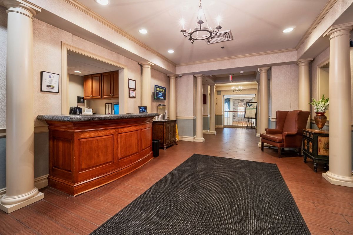 A welcoming hotel lobby featuring a wooden reception desk and elegant lighting.