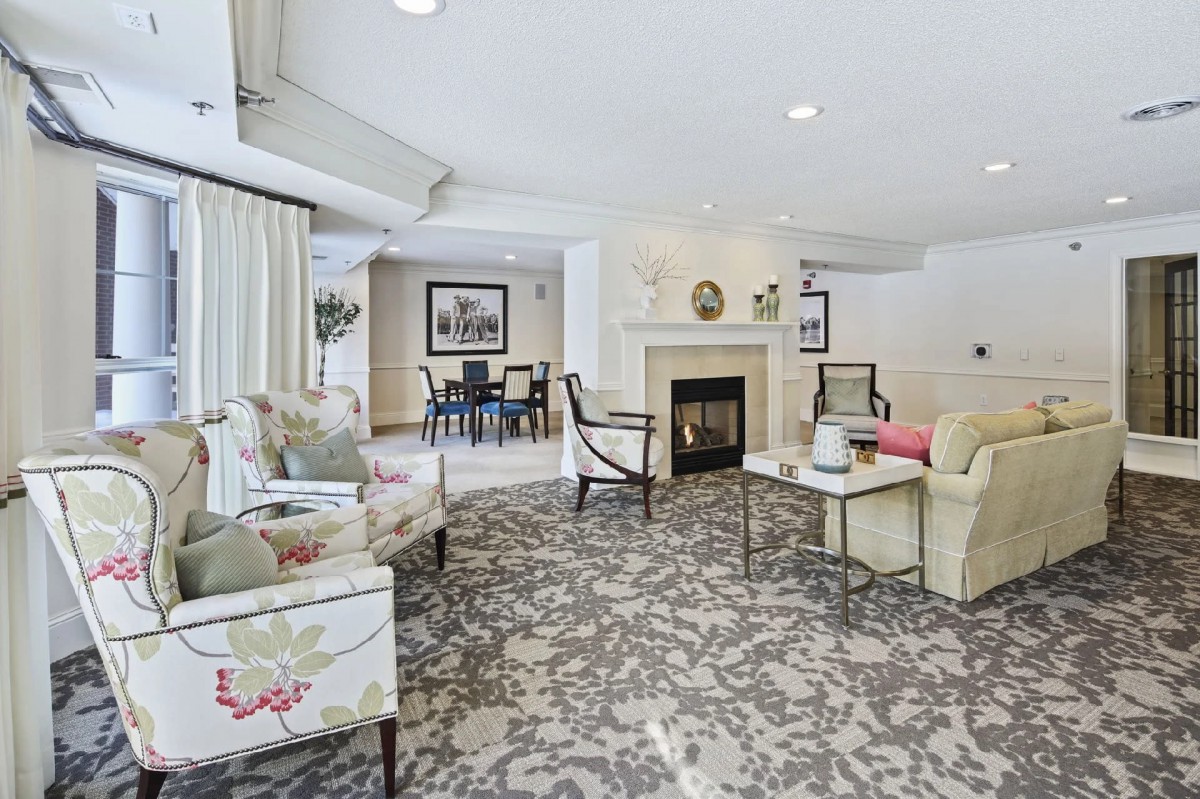 A cozy living room with stylish furniture and a central fireplace.