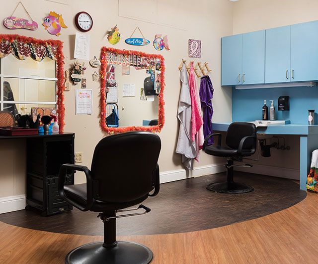 An interior view of a hair salon with styling stations, mirrors, and chairs.