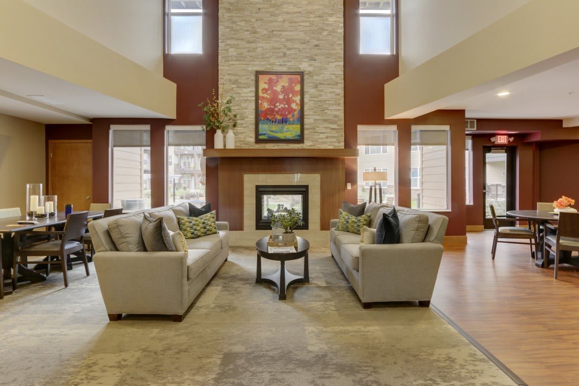 A spacious and elegantly designed living room featuring a central fireplace and modern sofas.
