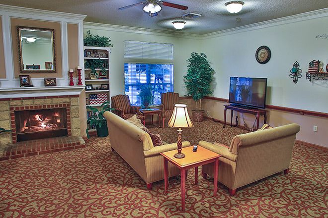 A cozy living room with sofas, a fireplace, and a television.