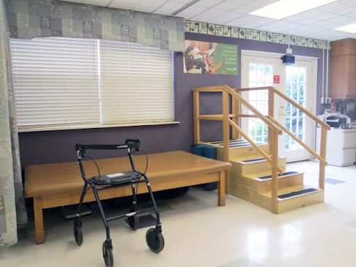A rehabilitation space featuring a walker and a set of stairs for physical therapy.