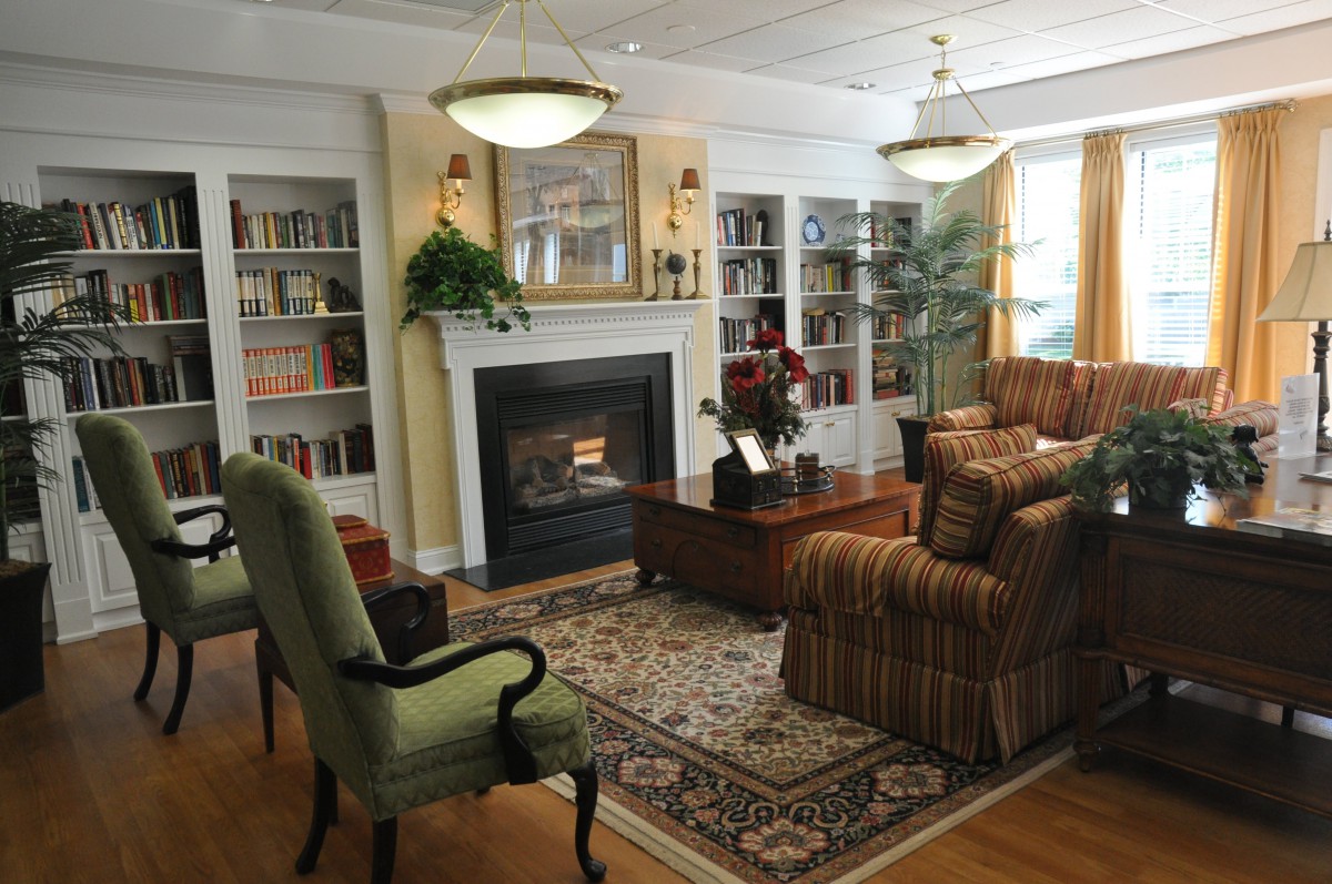 A cozy living room with a fireplace, bookshelves, and comfortable seating.