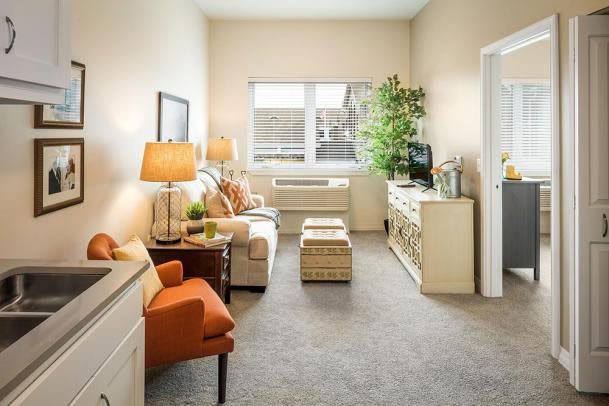 A cozy living room with modern furniture and a large window.