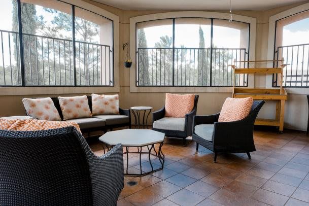 A cozy indoor lounge area with cushioned seating and large windows.
