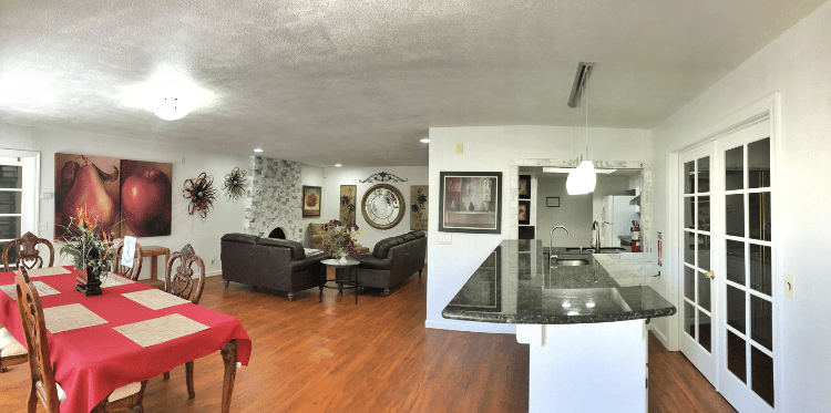 A spacious open floor plan featuring a modern living room and kitchen with hardwood floors and stylish decor.