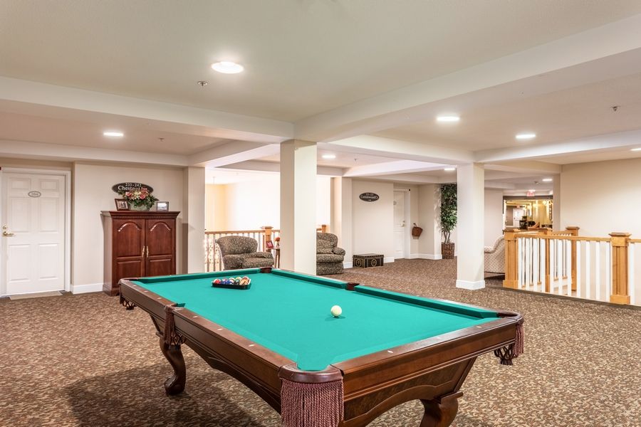 A cozy game room featuring a pool table and comfortable seating.