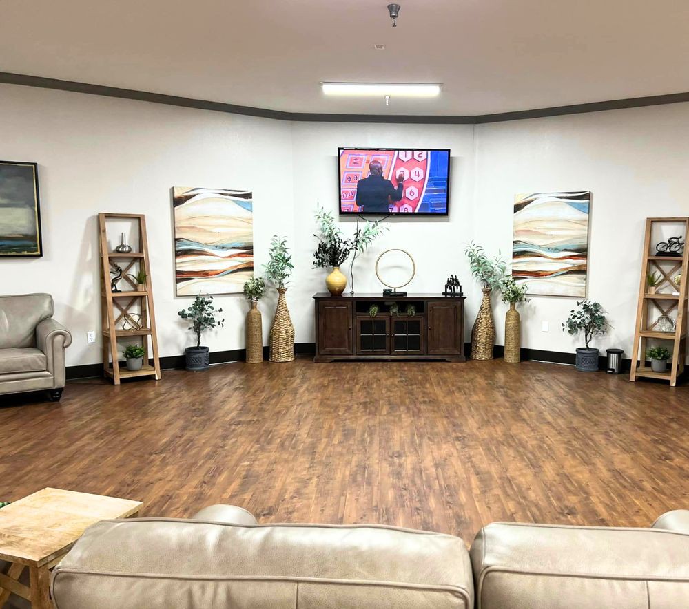 A modern living room with wood flooring, stylish decor, and a television mounted on the wall.