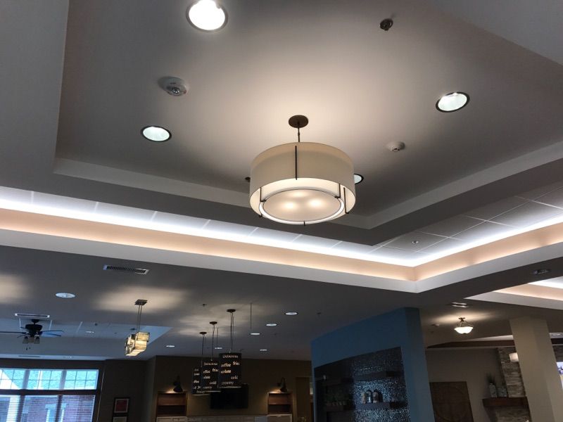 A modern interior featuring a combination of recessed and pendant lighting on the ceiling.