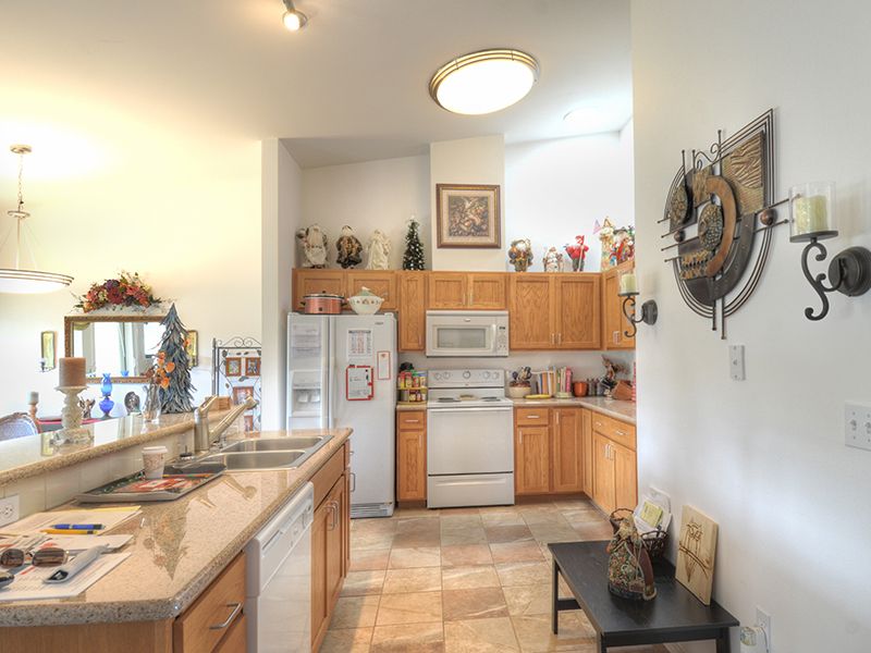 A cozy kitchen with wooden cabinets, white appliances, and decorative elements.