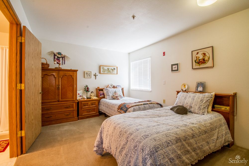 A cozy bedroom with two beds and wooden furniture.
