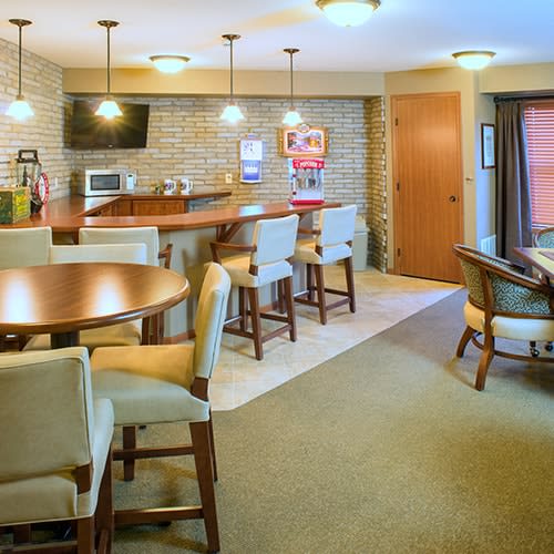 A modern kitchen with a seating area featuring bar stools and a table with chairs.