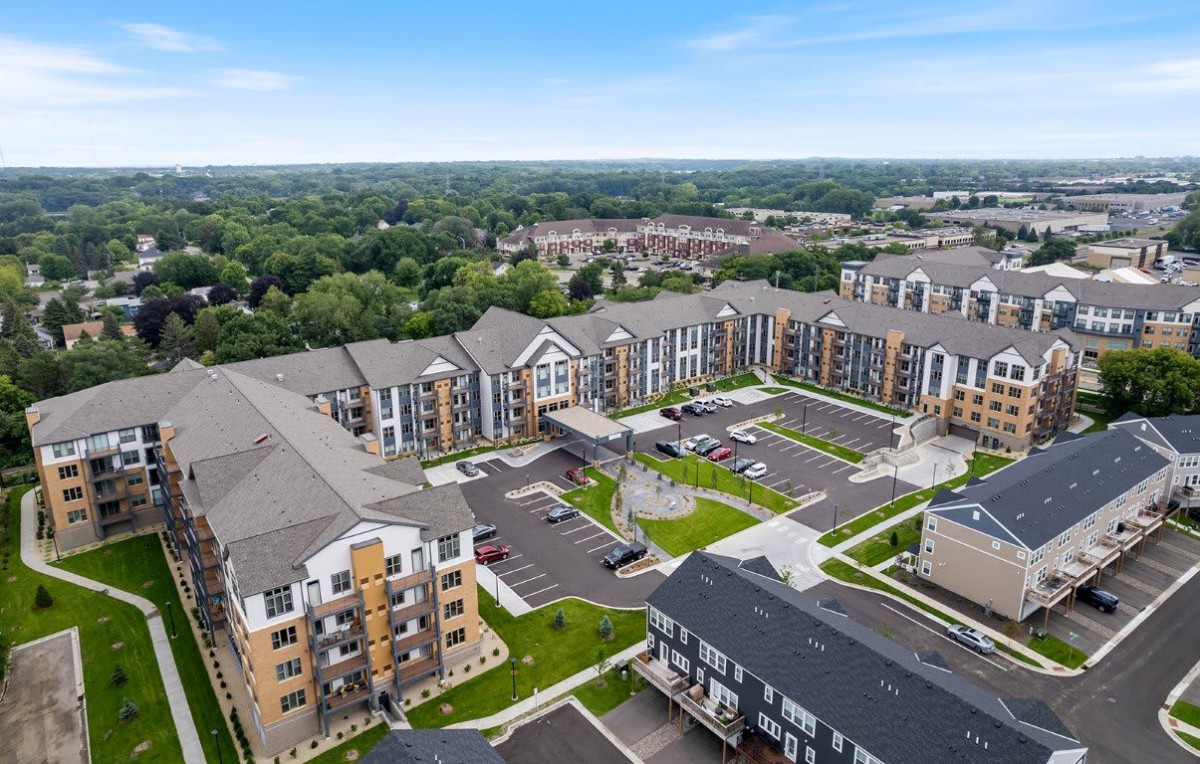 Aerial view of a modern apartment complex surrounded by lush greenery.
