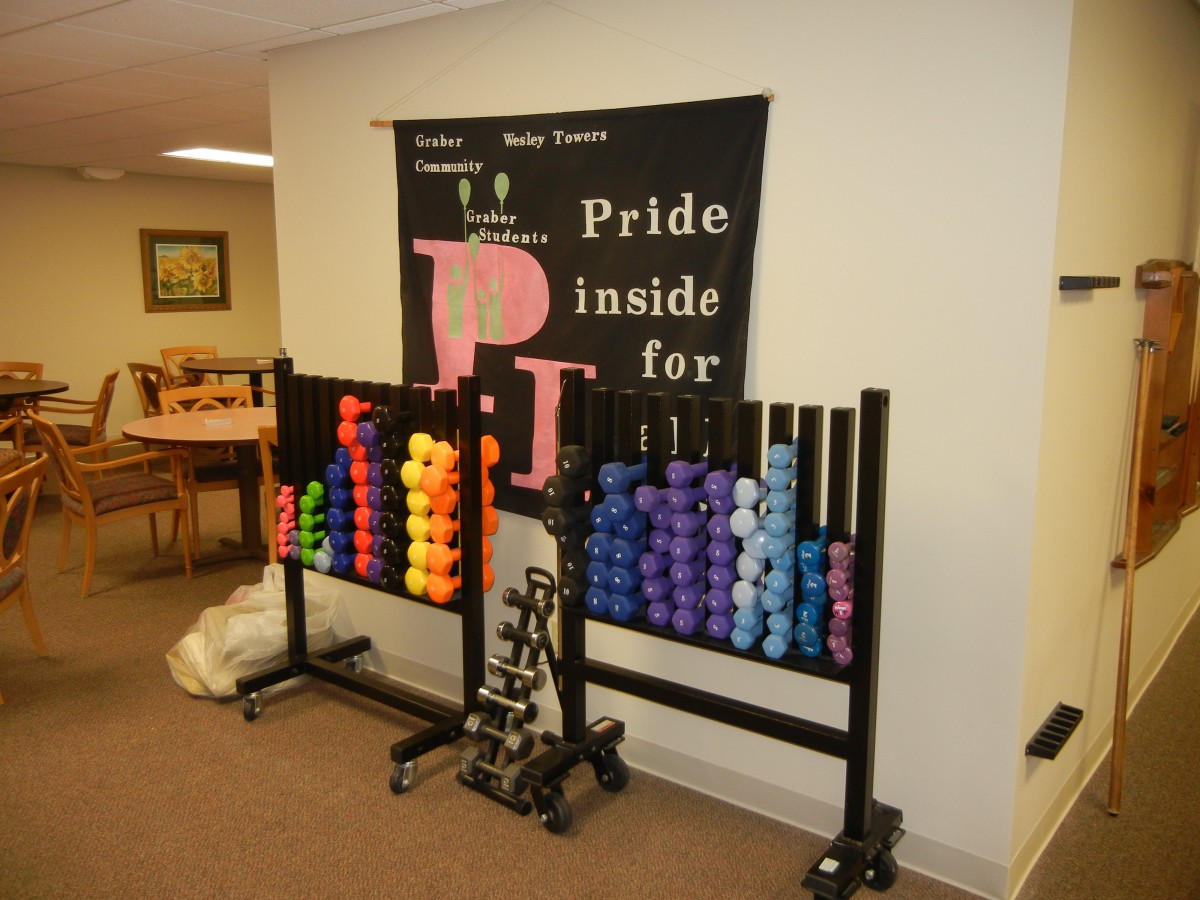 A colorful array of dumbbells organized on racks in a fitness area.