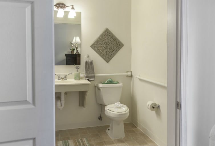 A clean and minimalistic bathroom with a toilet, sink, and mirror.