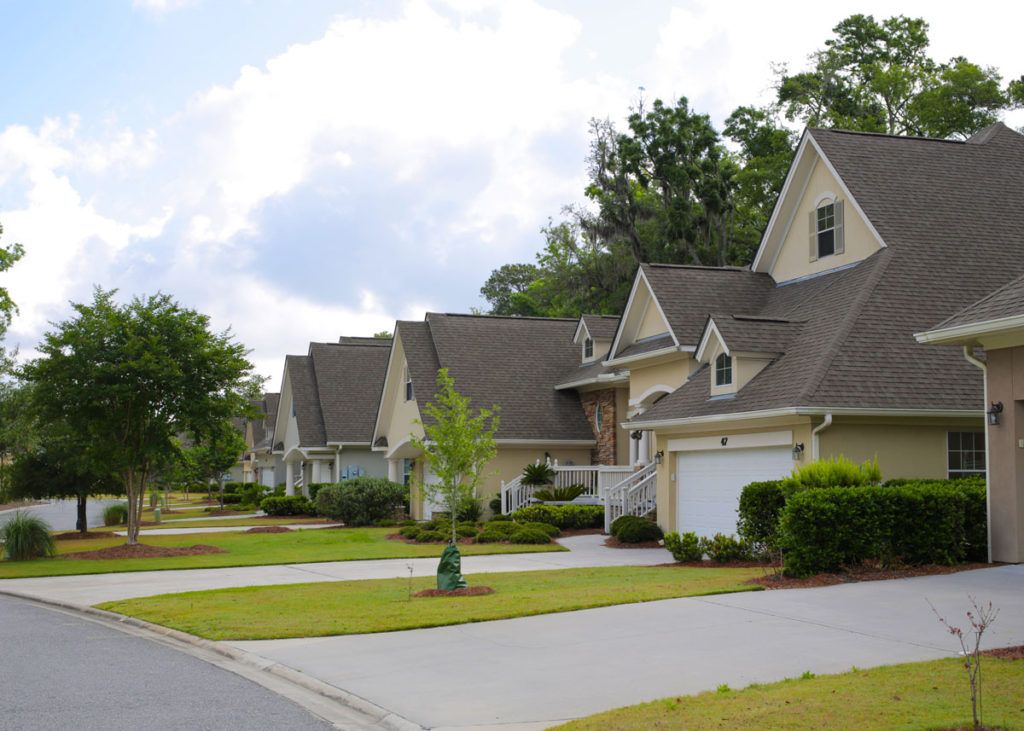 A quiet suburban neighborhood with a row of similar-style houses.