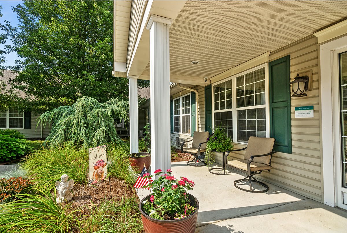 A welcoming front porch with outdoor seating and potted plants.