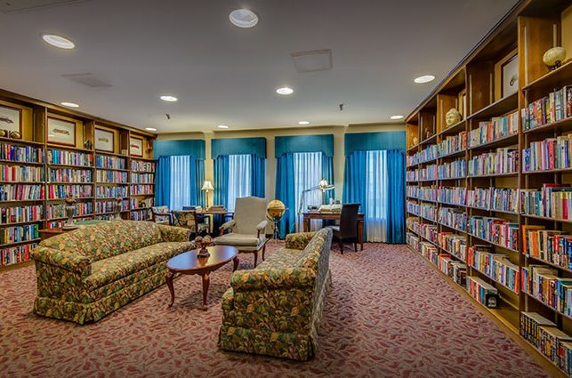 A cozy library with sofas and bookshelves lining the walls, offering a comfortable reading environment.