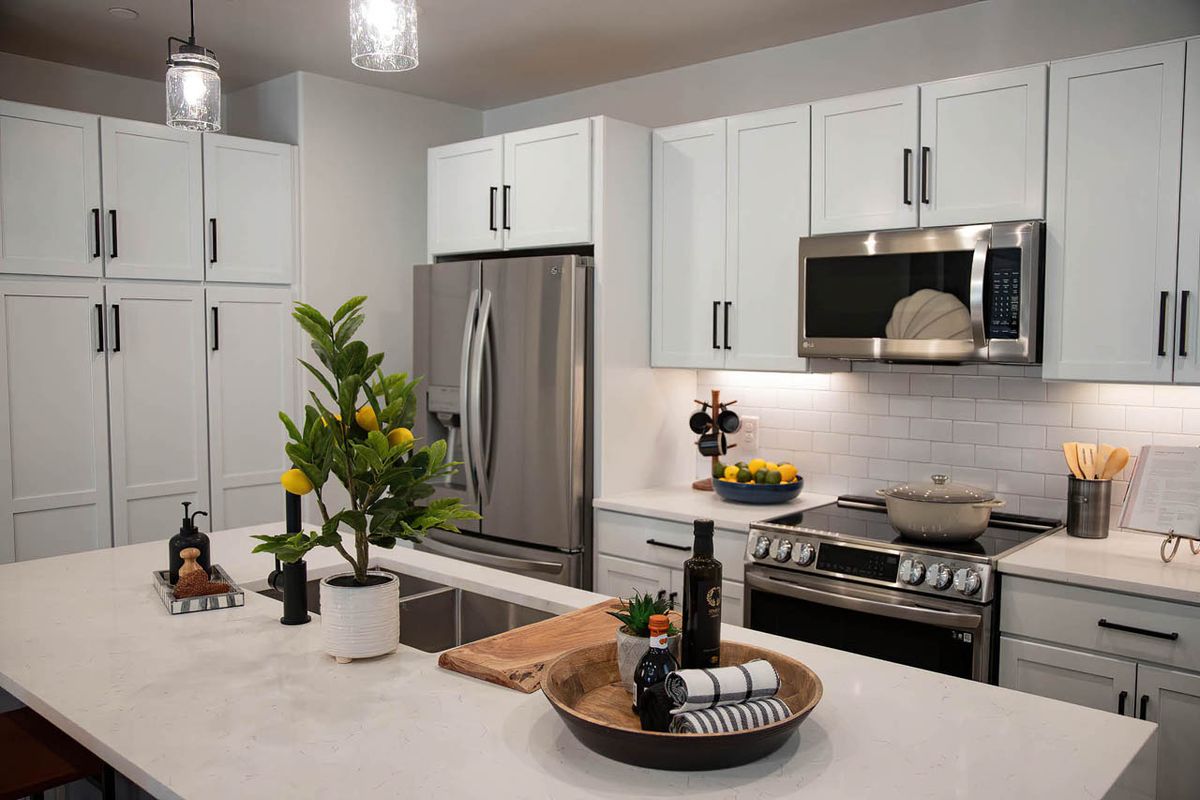 A modern kitchen with stainless steel appliances and white cabinets.