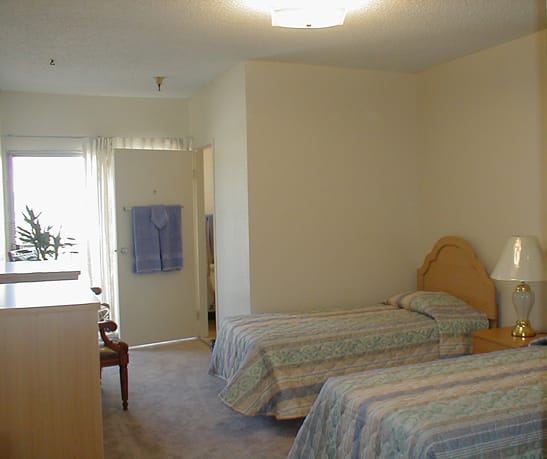 A cozy bedroom with twin beds and simple decor.