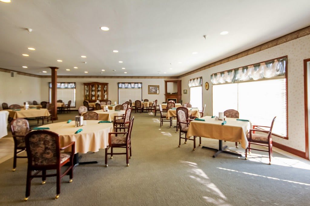 A well-lit dining area with neatly arranged tables and chairs.
