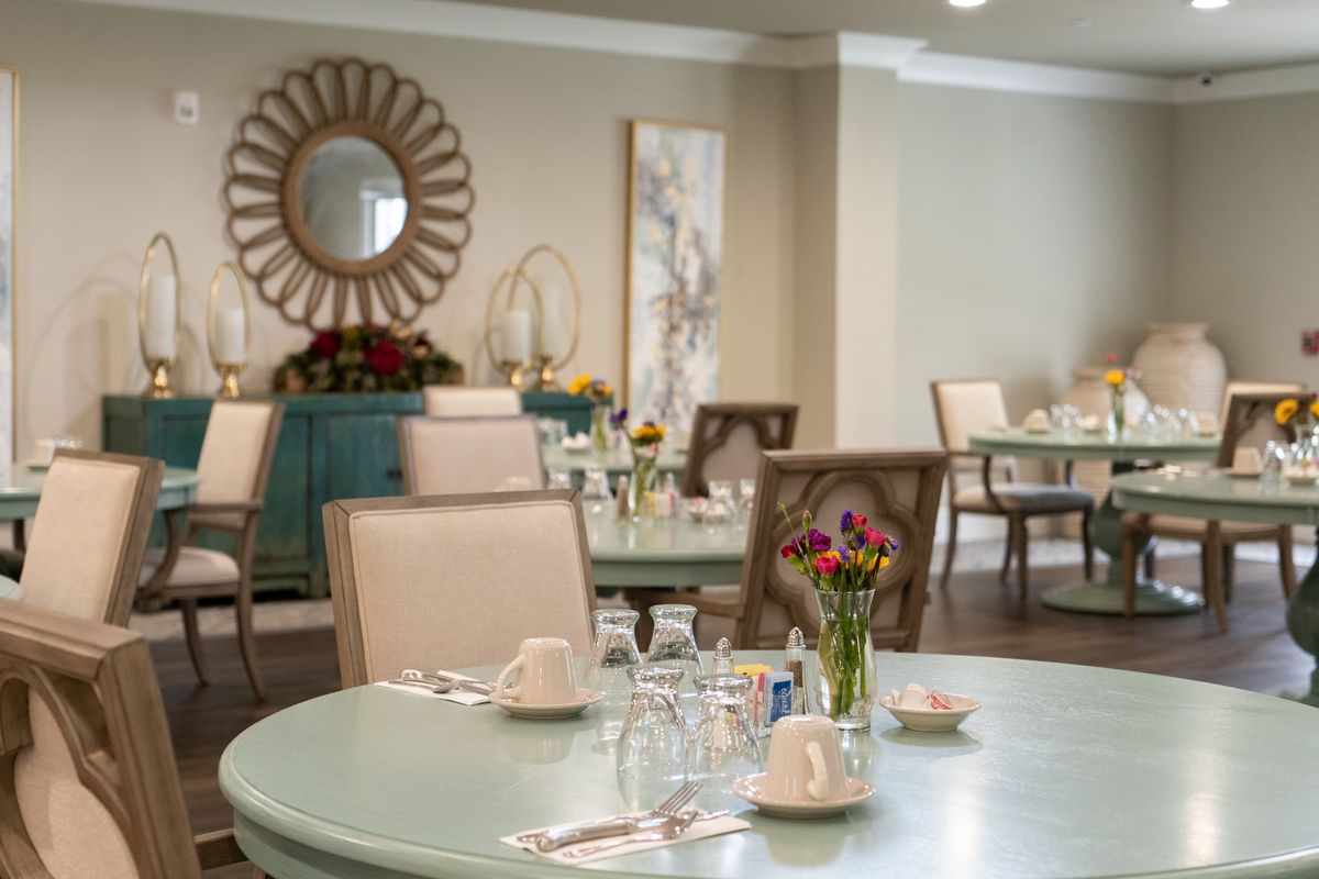 An elegantly decorated dining room with set tables and floral arrangements.