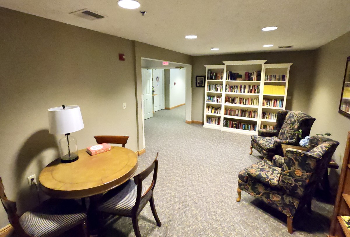 A cozy indoor library space with bookshelves and reading furniture.