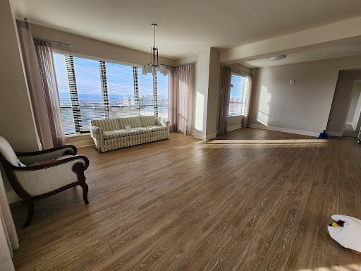 A spacious and bright living room featuring large windows, offering a panoramic view and an inviting atmosphere.