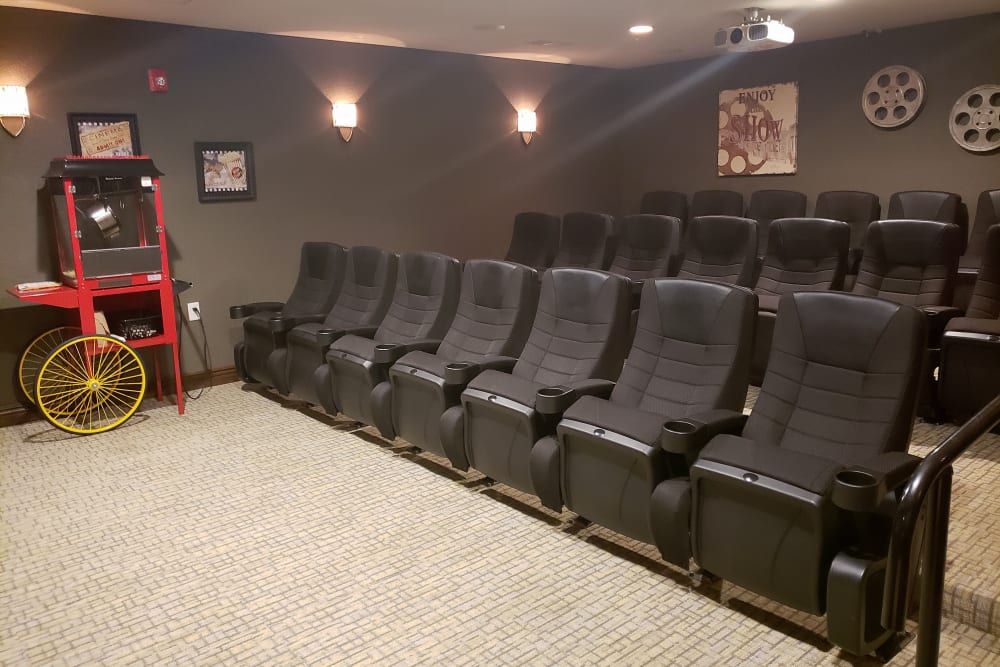 A cozy home theater setup with multiple rows of comfortable seating and movie-themed decor.