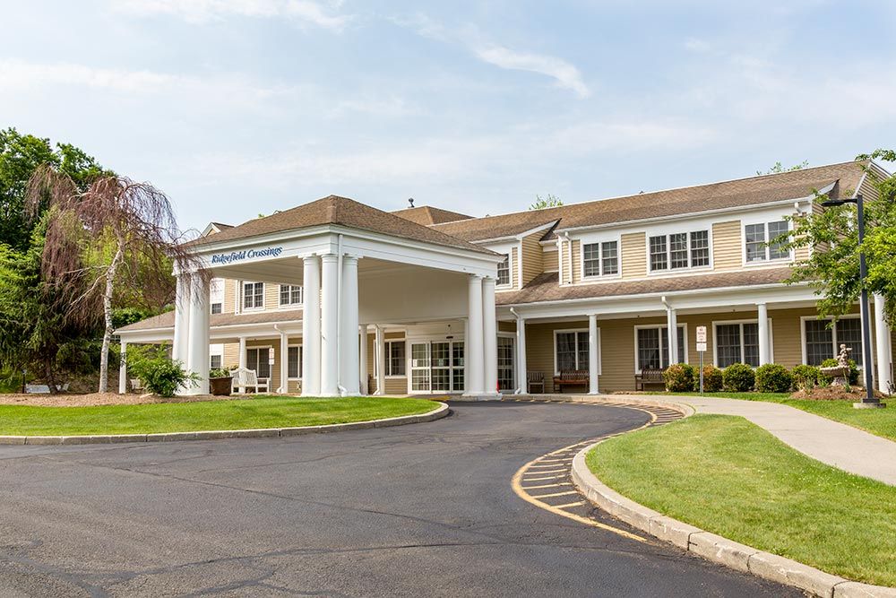 A large building with a prominent entrance featuring white columns and a curved driveway.